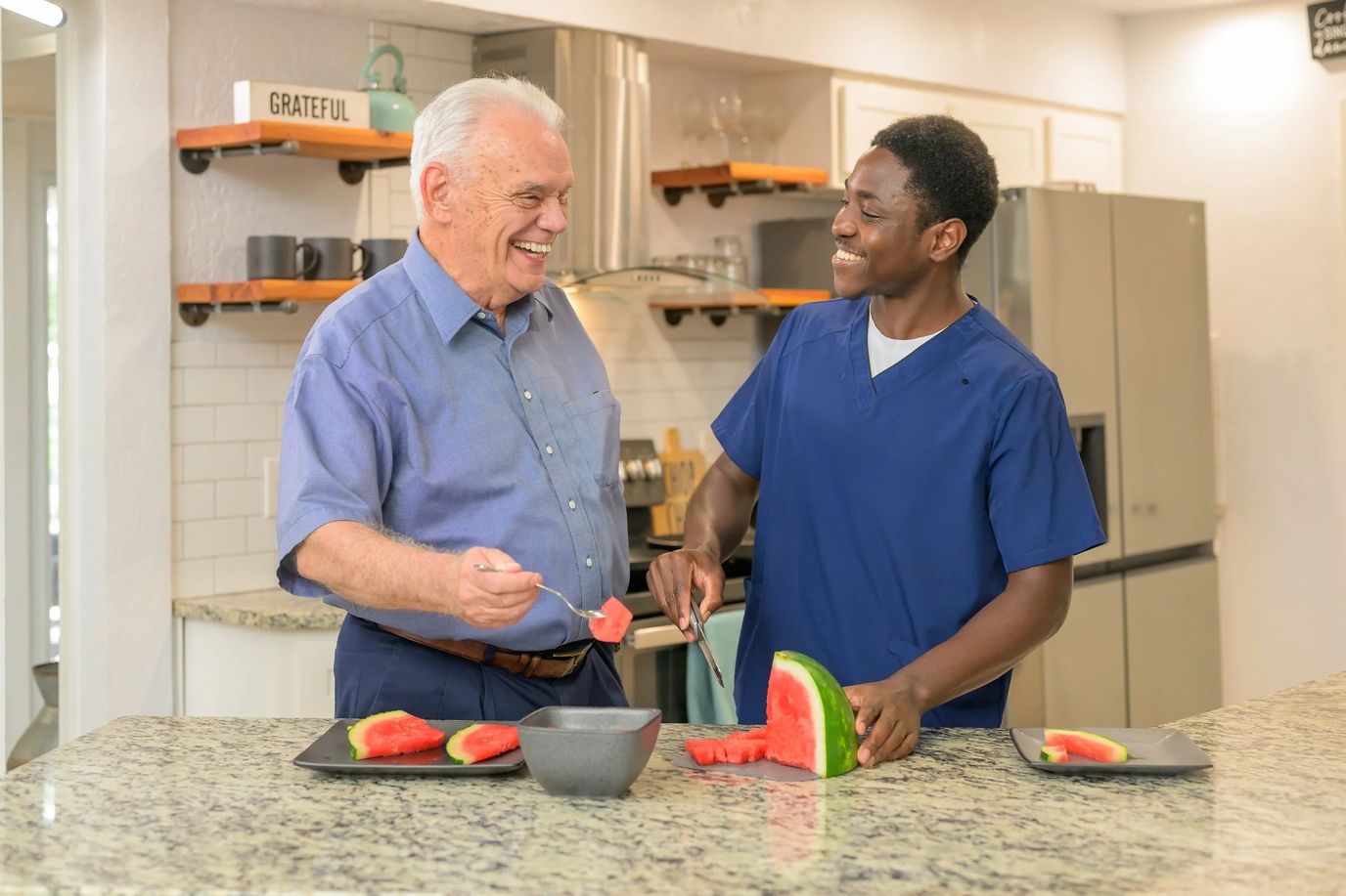 Care staff preparing watermelon with a resident.