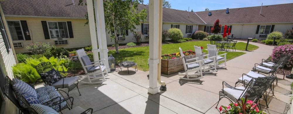 Bickford of Saginaw Township, assisted living in Saginaw, MI — Courtyard with rocking chairs and landscaped gardens