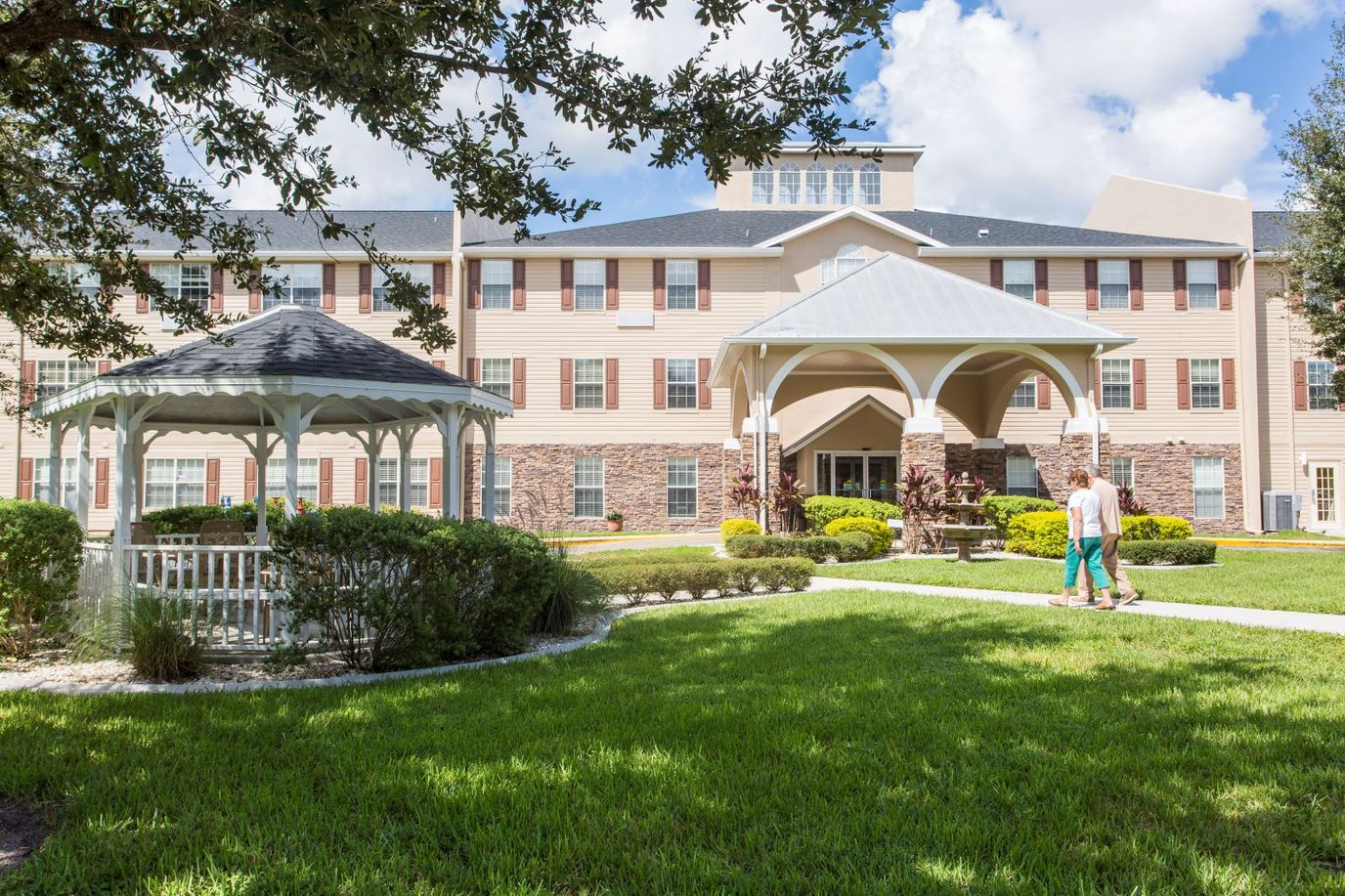 Residents walking in the outdoor garden area of the facility