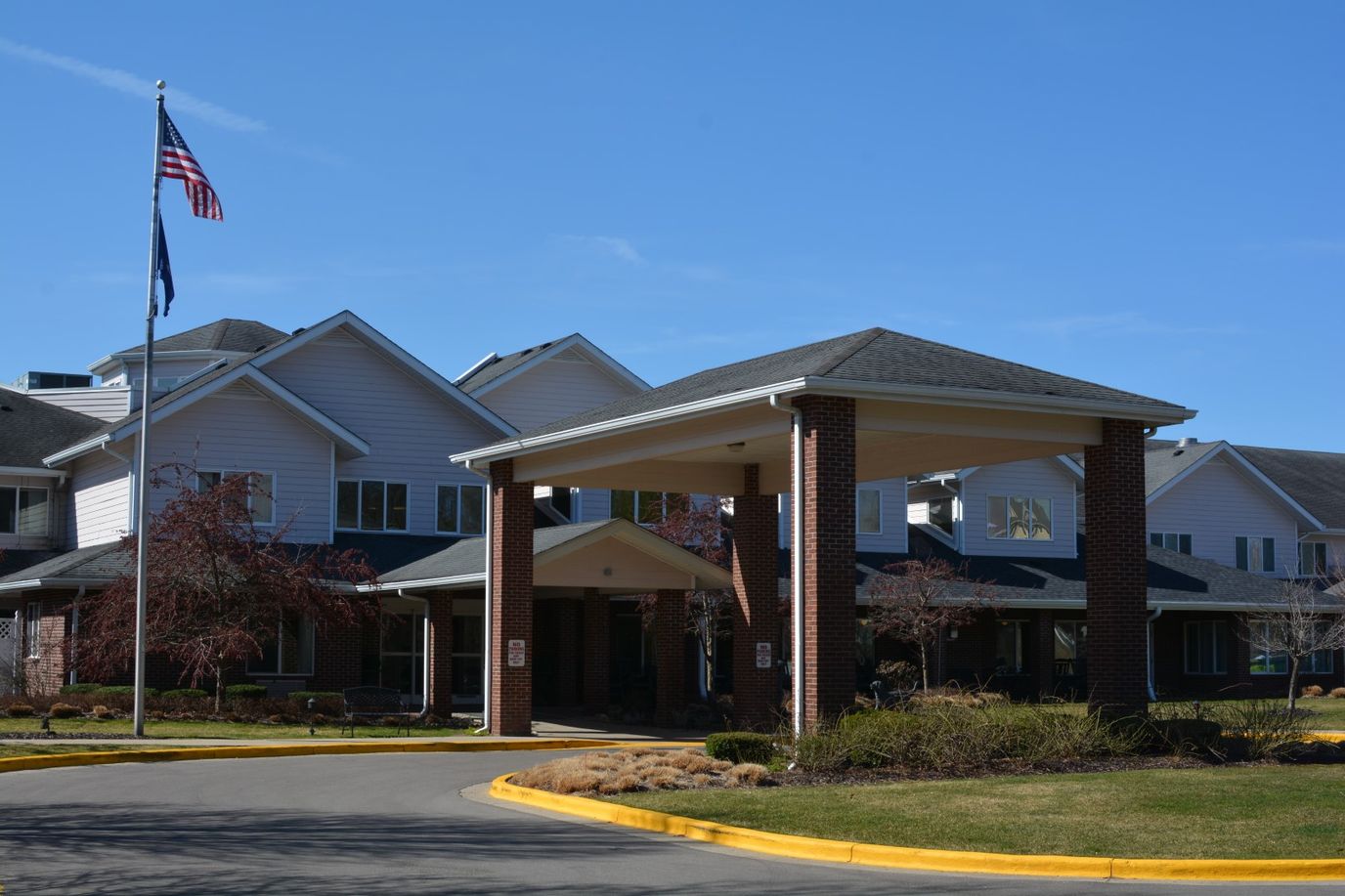 Front entrance of a senior living facility with flag
