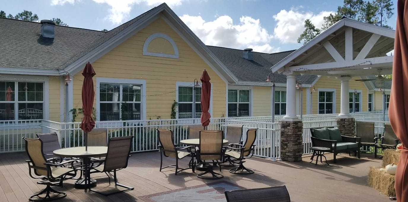 Exterior of Magnolia Manor assisted living facility with outdoor seating