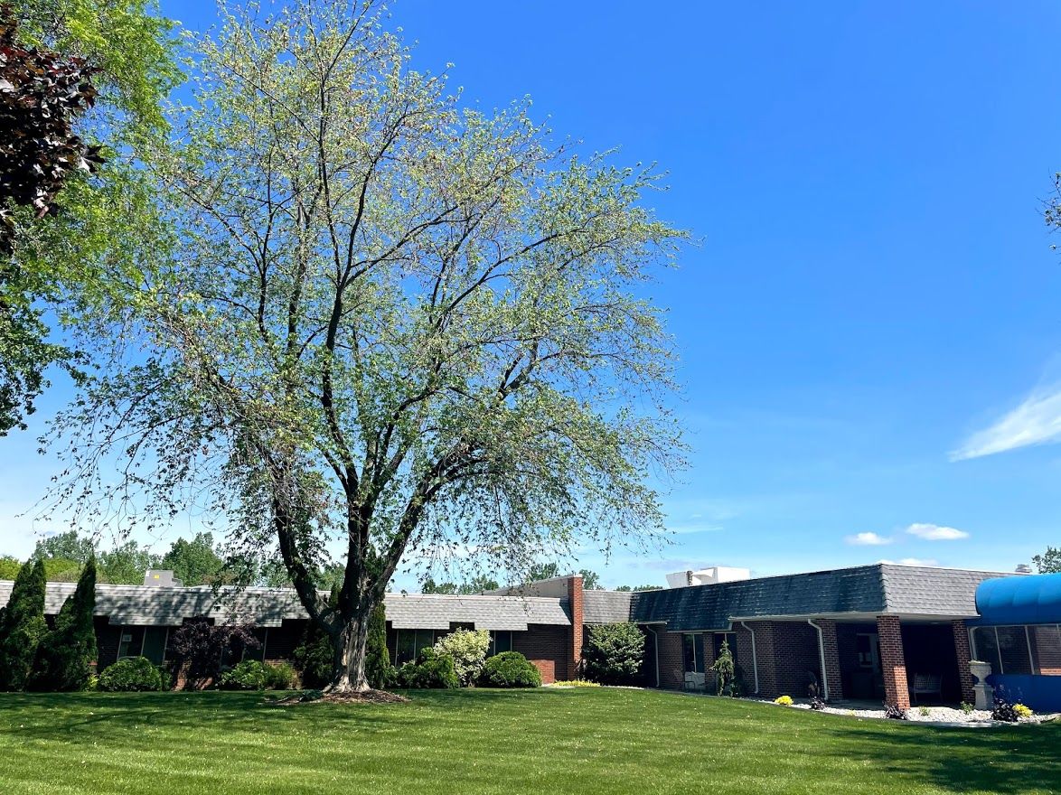 Exterior view of the assisted living facility surrounded by greenery
