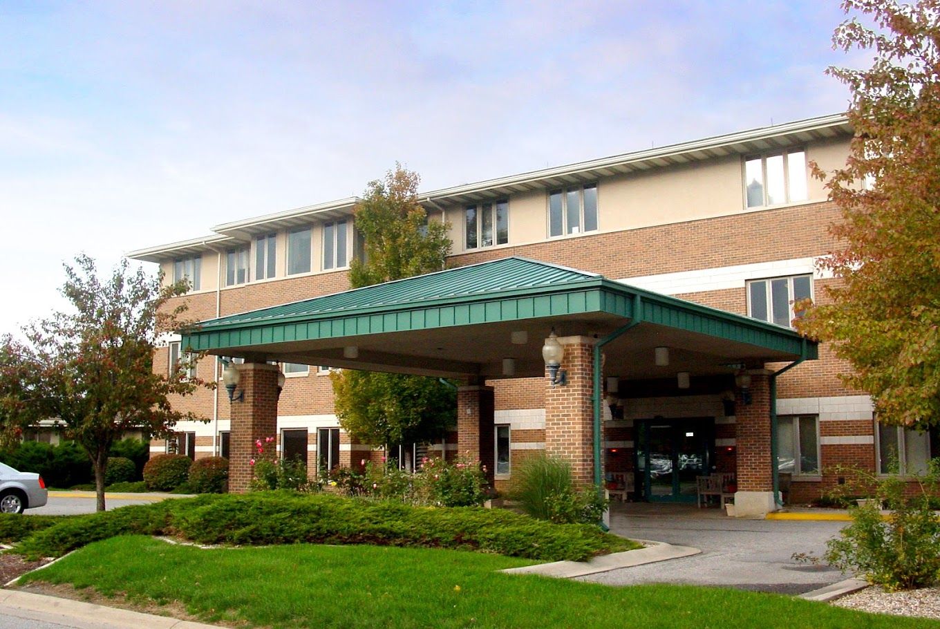 Entrance of a nursing home facility surrounded by landscaping