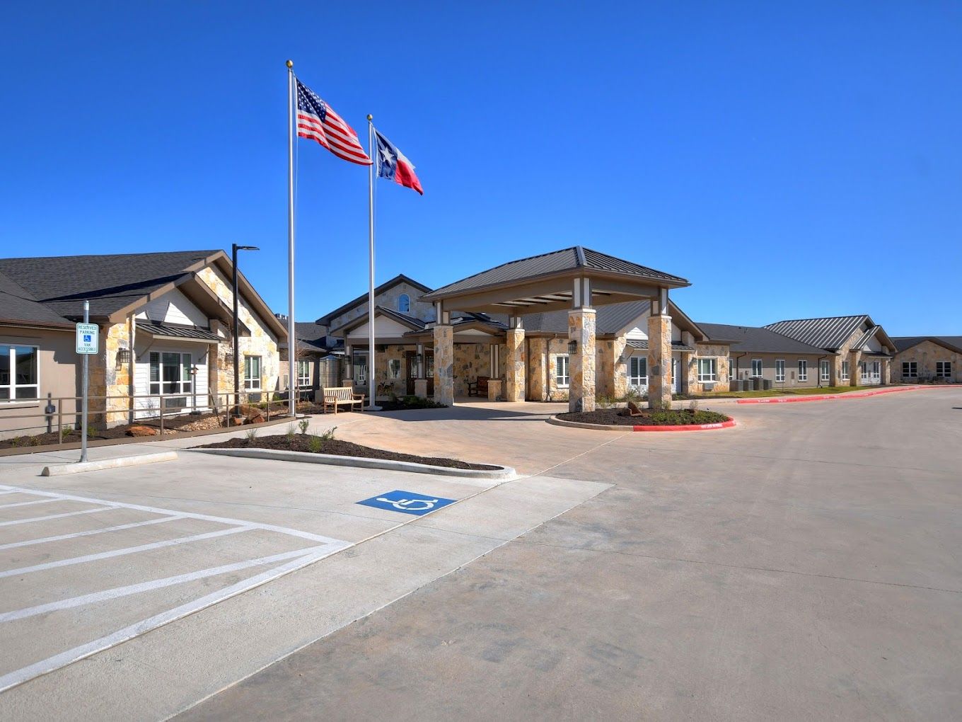 Exterior view of Alexis Pointe Senior Living with flags