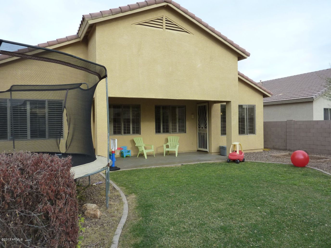 Exterior view of a house with outdoor seating and a trampoline