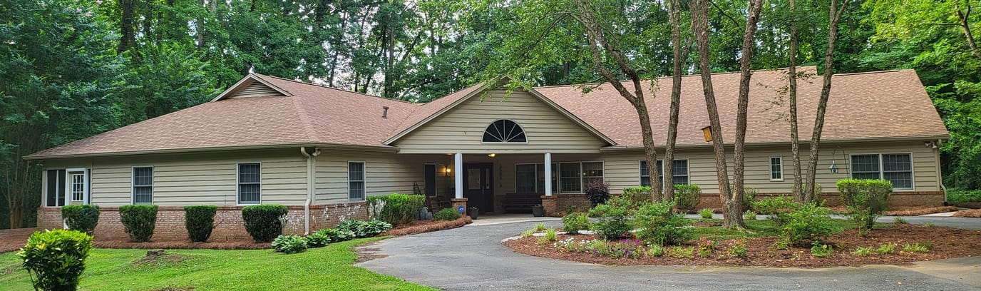 Exterior view of the House of Peace facility surrounded by trees