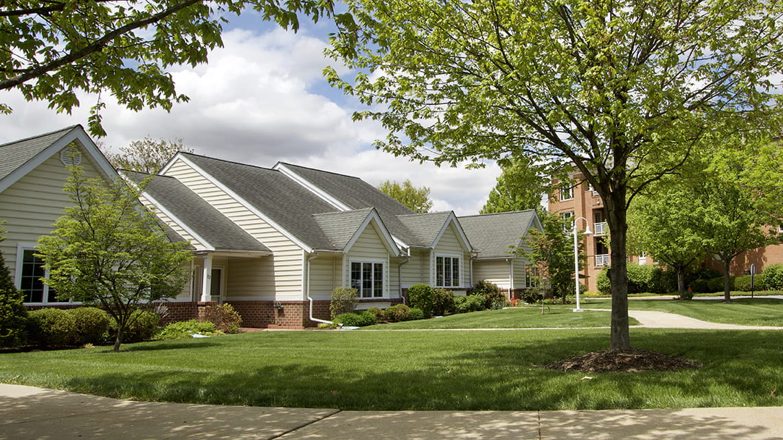 Exterior view of a senior living facility surrounded by greenery