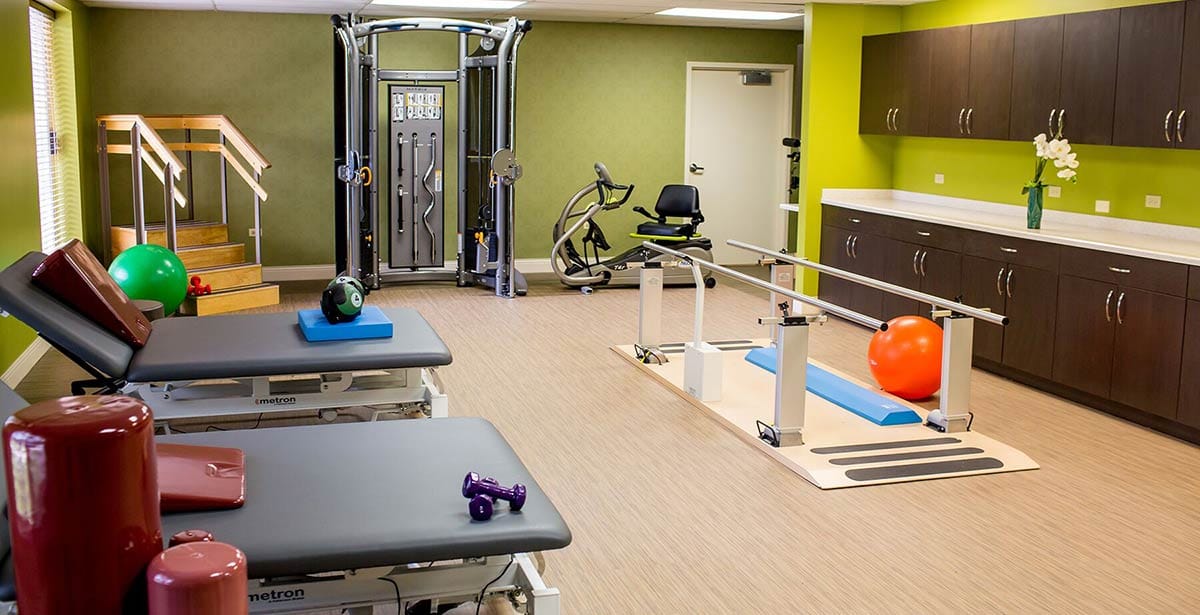 Physical therapy gym with exercise equipment and therapy tools