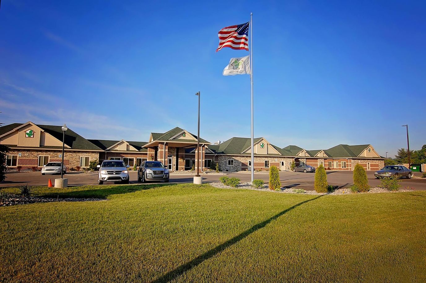 Exterior view of Bay City Comfort Care with flags and vehicles