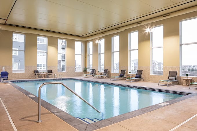 Indoor pool area with lounge chairs and large windows