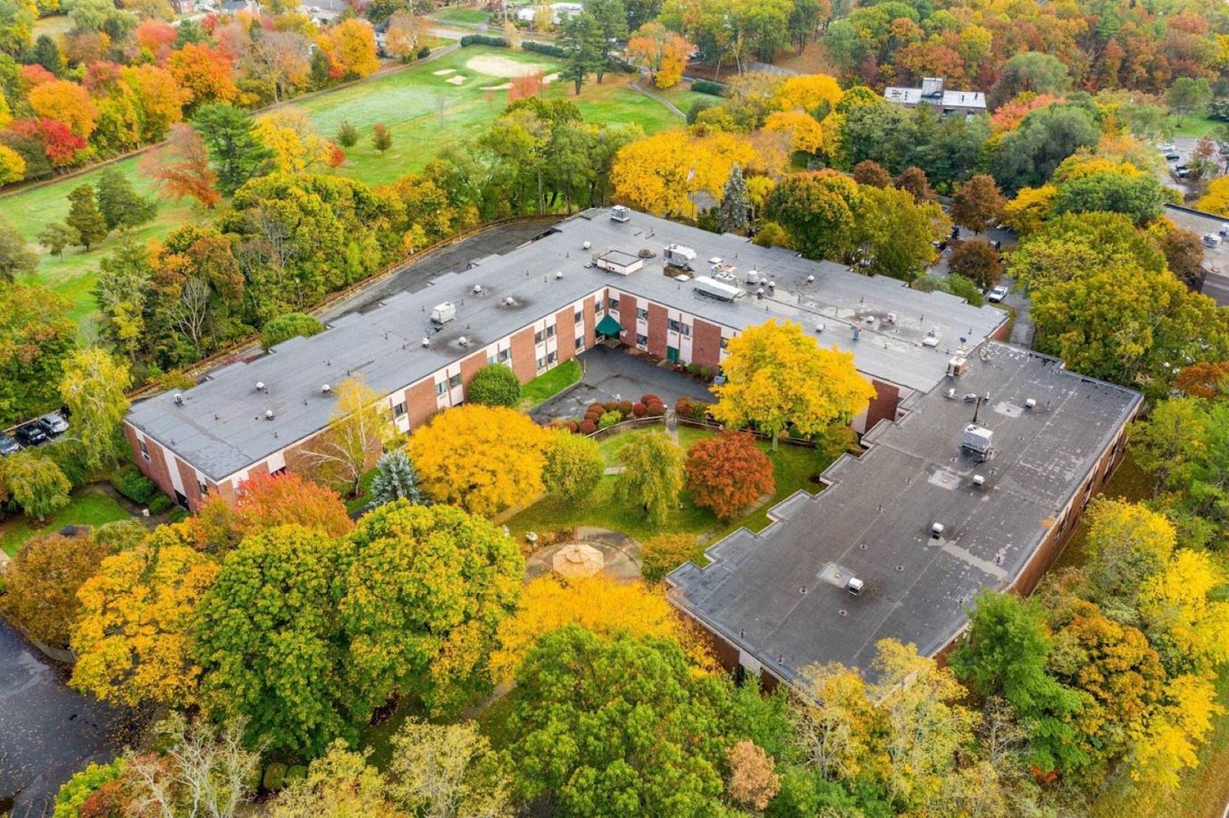 Aerial view of Bear Hill Rehabilitation and Nursing Center surrounded by autumn trees