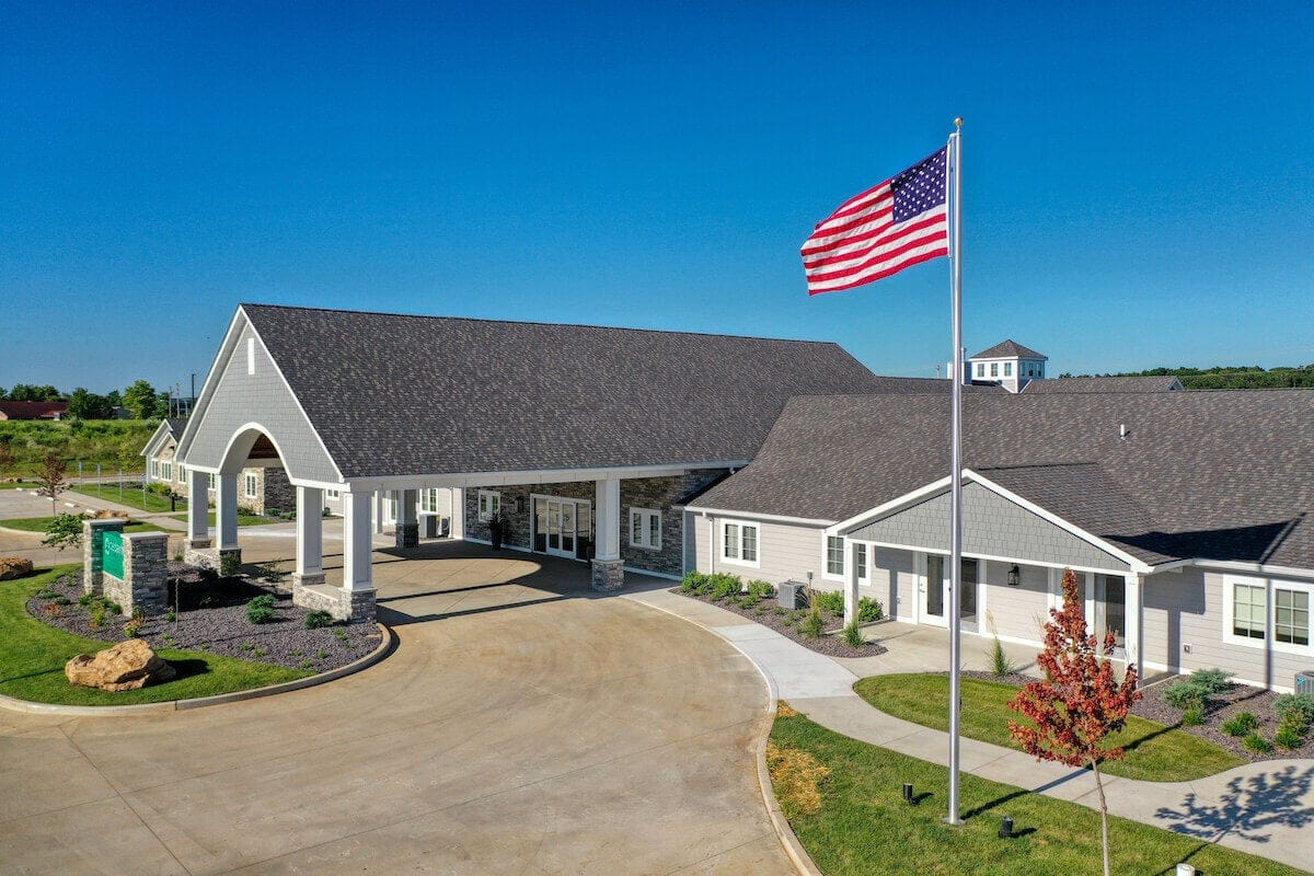 Aerial view of Cedarhurst of Farmington building with flag