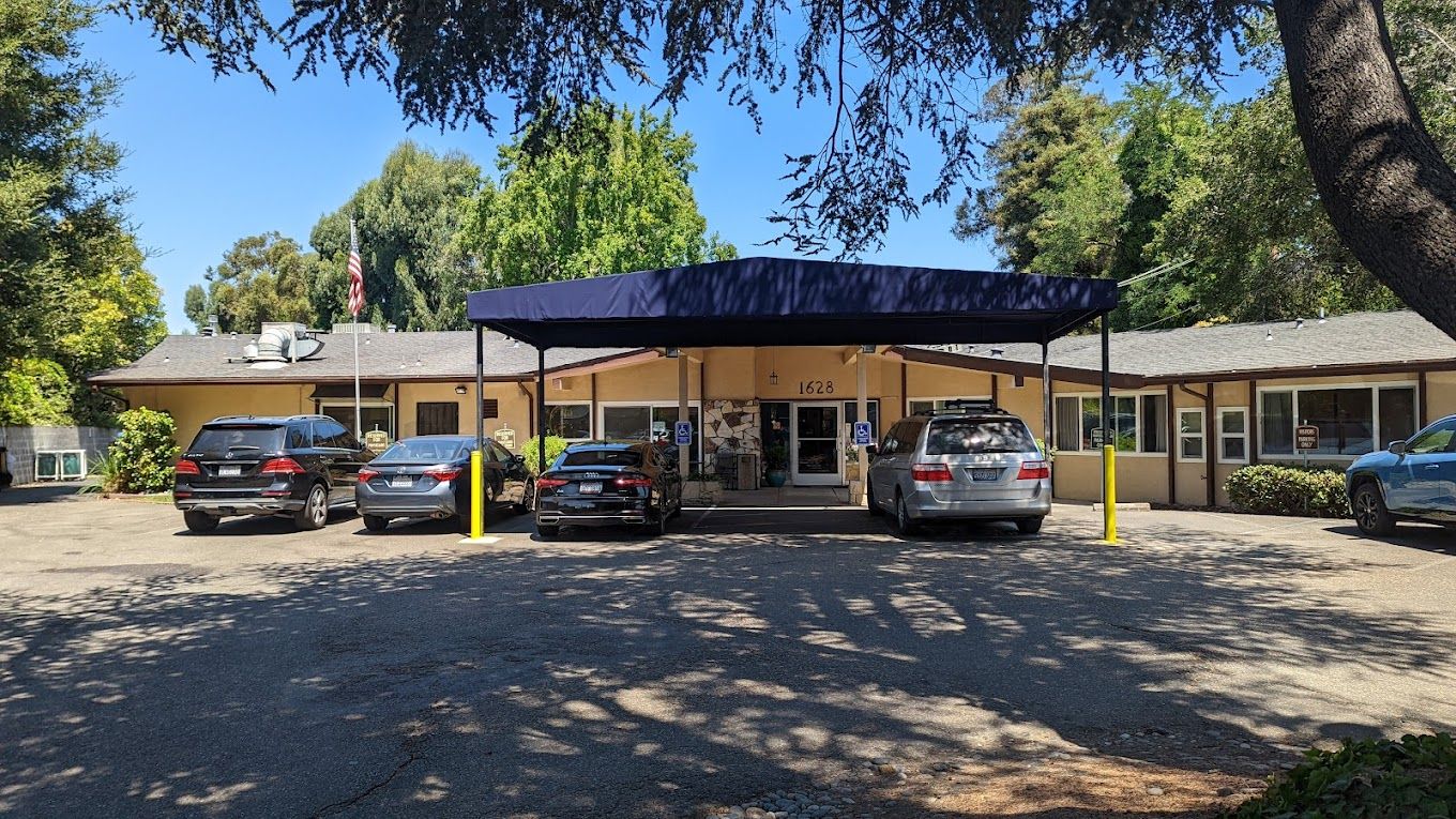Front entrance of Hayward Gardens Post Acute facility with vehicles