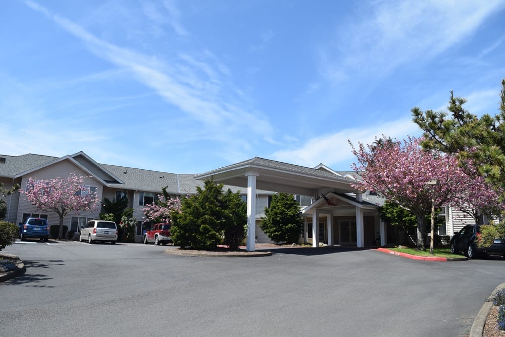 Exterior view of a senior living facility with blooming trees