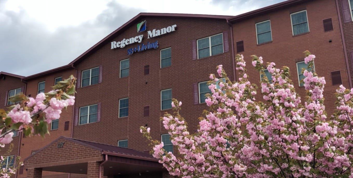 Exterior view of Regency Manor with flowering trees