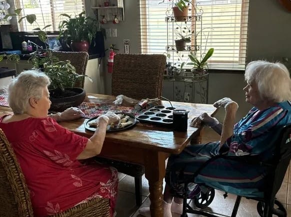 Two residents enjoying snacks at a dining table