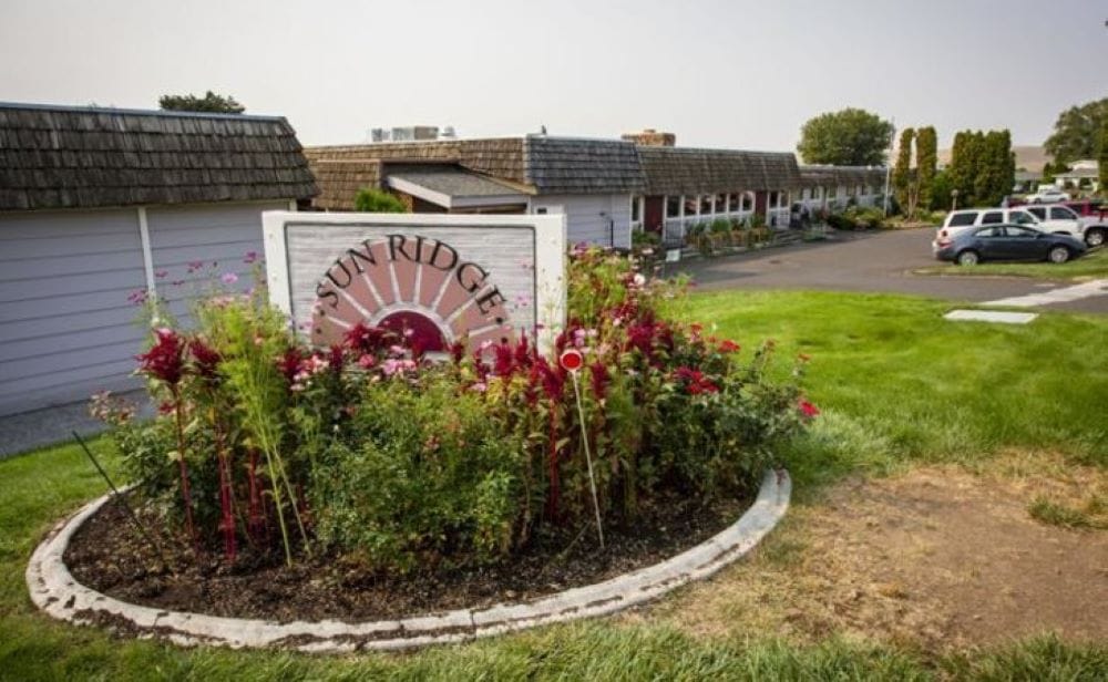 Signage of Sun Ridge Retirement surrounded by flowers