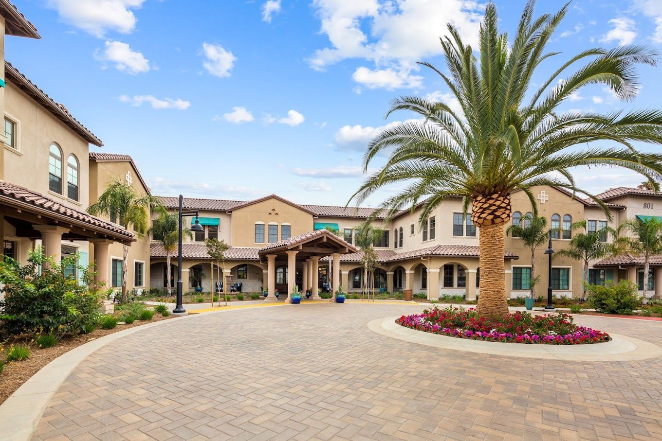 Exterior view of a senior living facility with palm trees