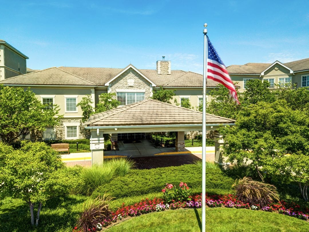 Front entrance of Town Village of Leawood with garden and flag