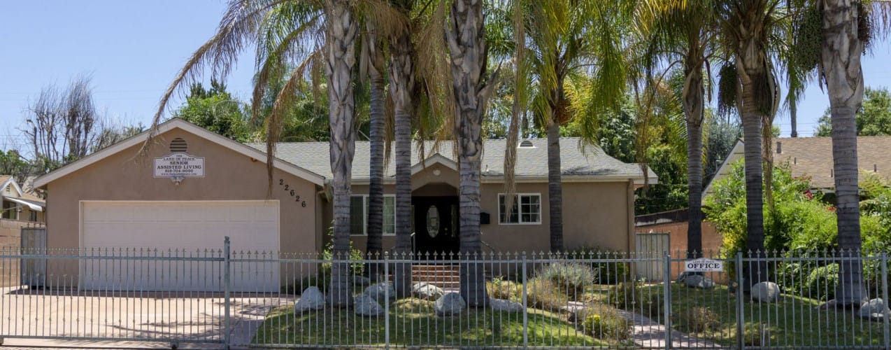 Exterior view of a senior living facility with palm trees