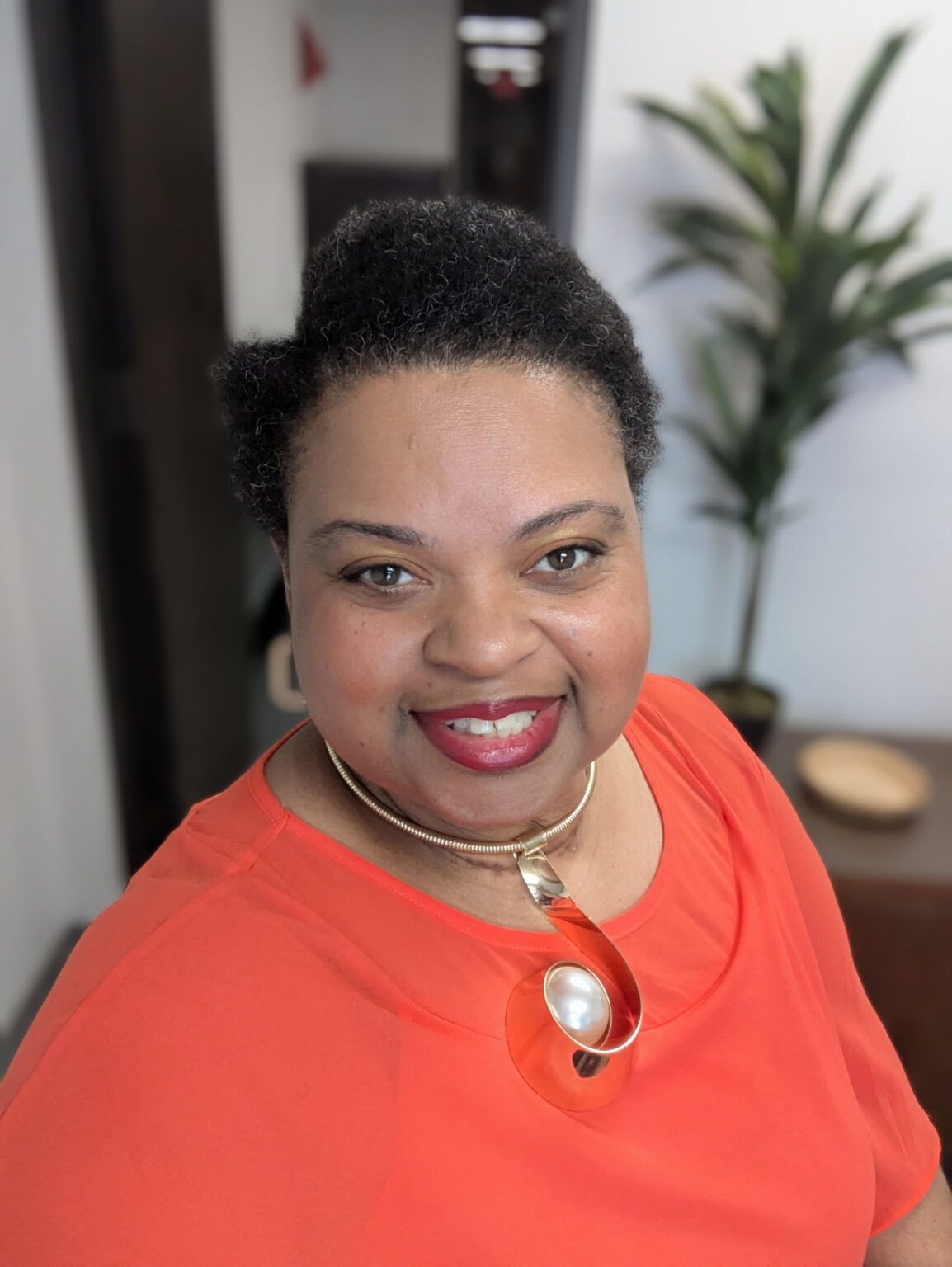 Griswold Home Care for Southeast Houston, home care in Houston, TX — Woman smiling in an orange top with accessories