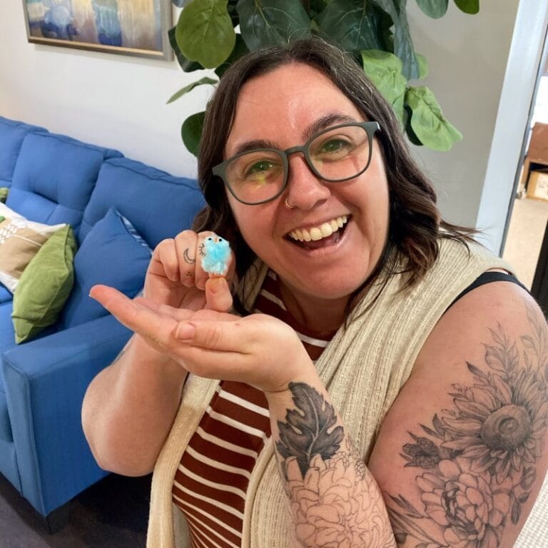 Staff member holding a decorated cupcake in a common area