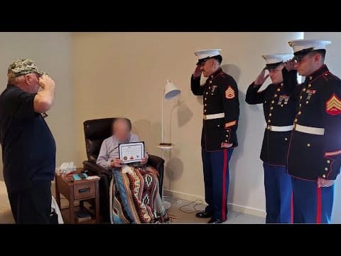 Veterans honoring a resident with a certificate.