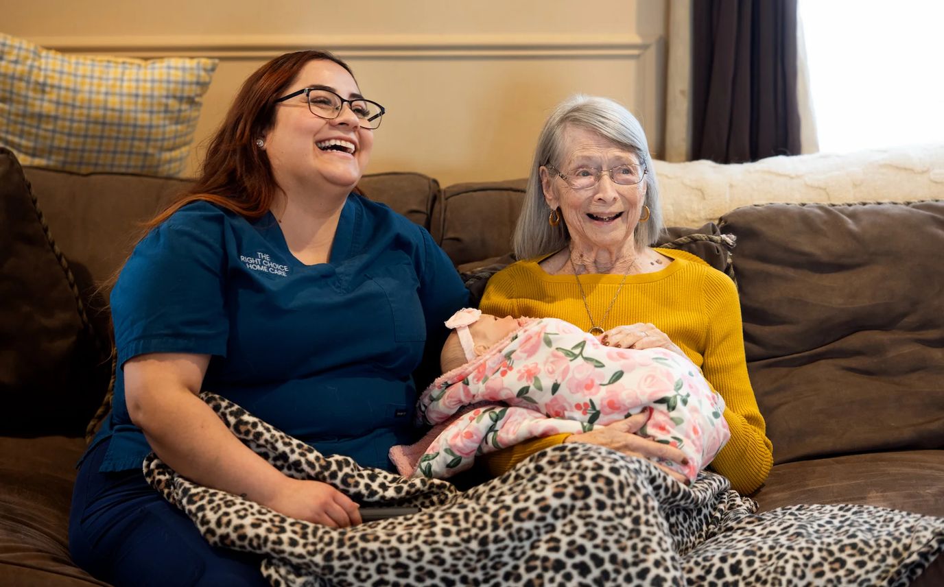 A caregiver and a senior woman smiling together