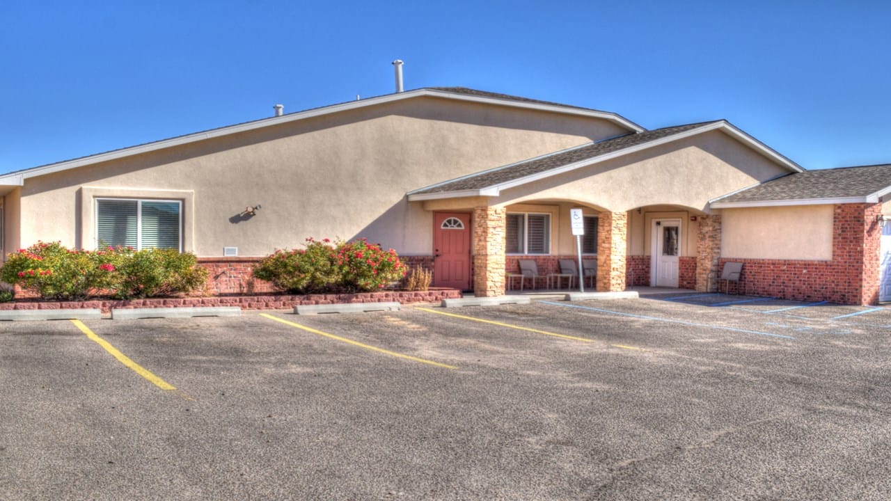 Exterior view of Beehive Homes with parking and landscaping