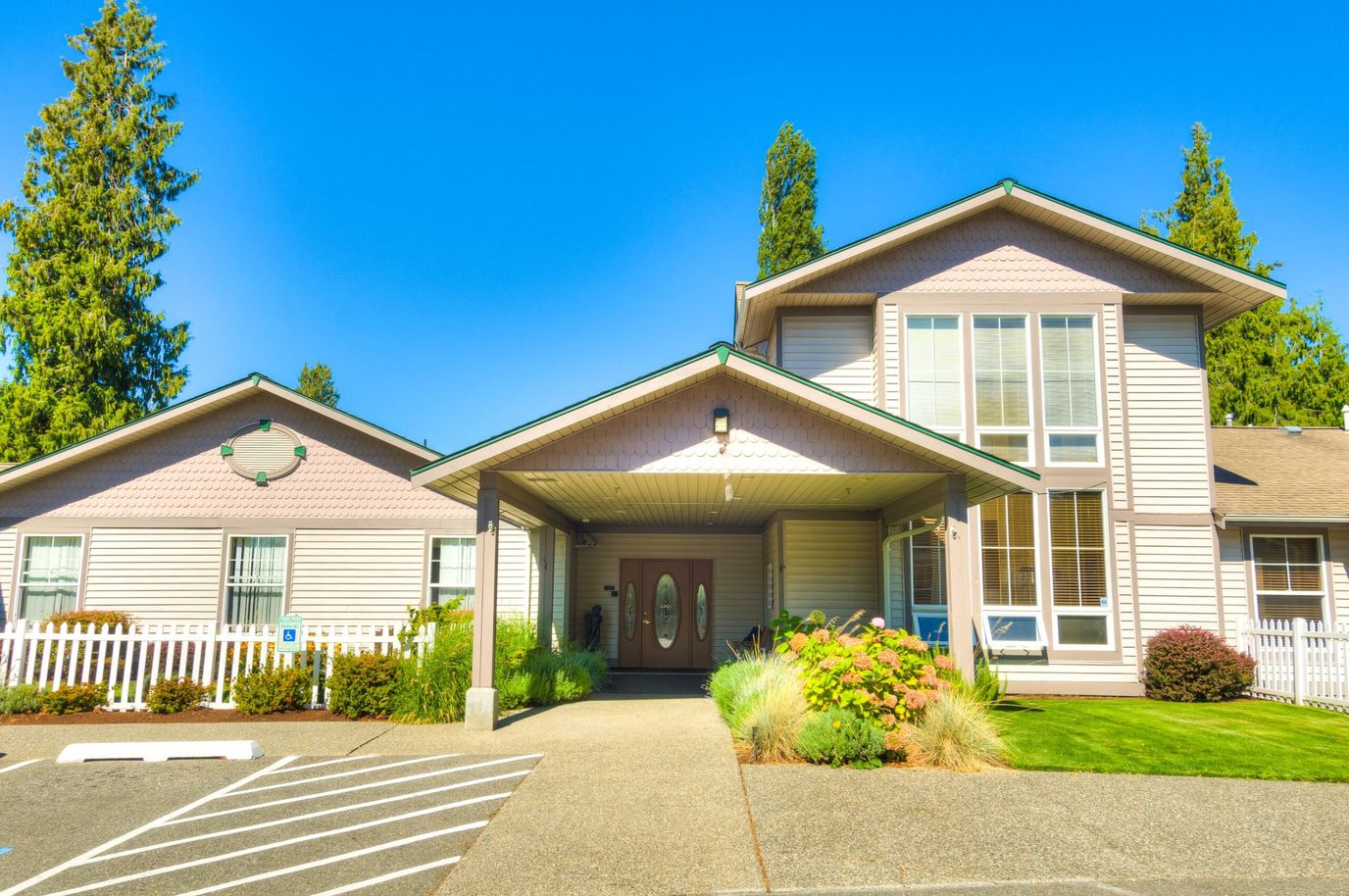 Exterior view of a senior living facility with gardens and entrance