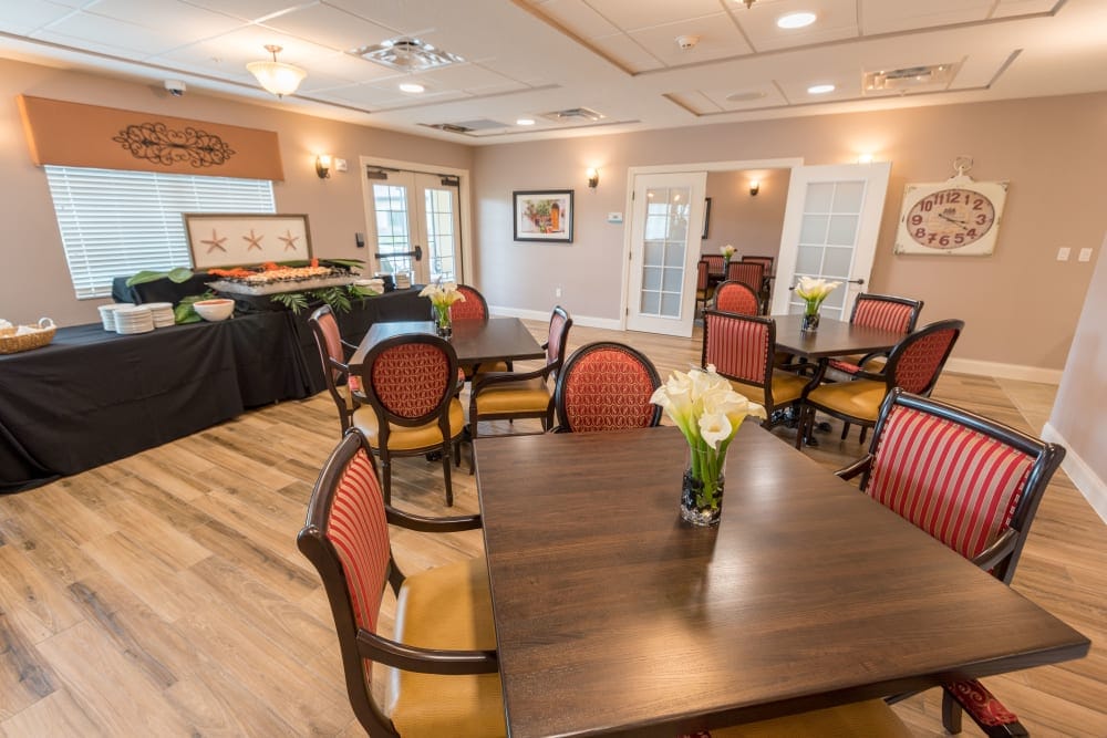 A dining room setup with tables and flowers