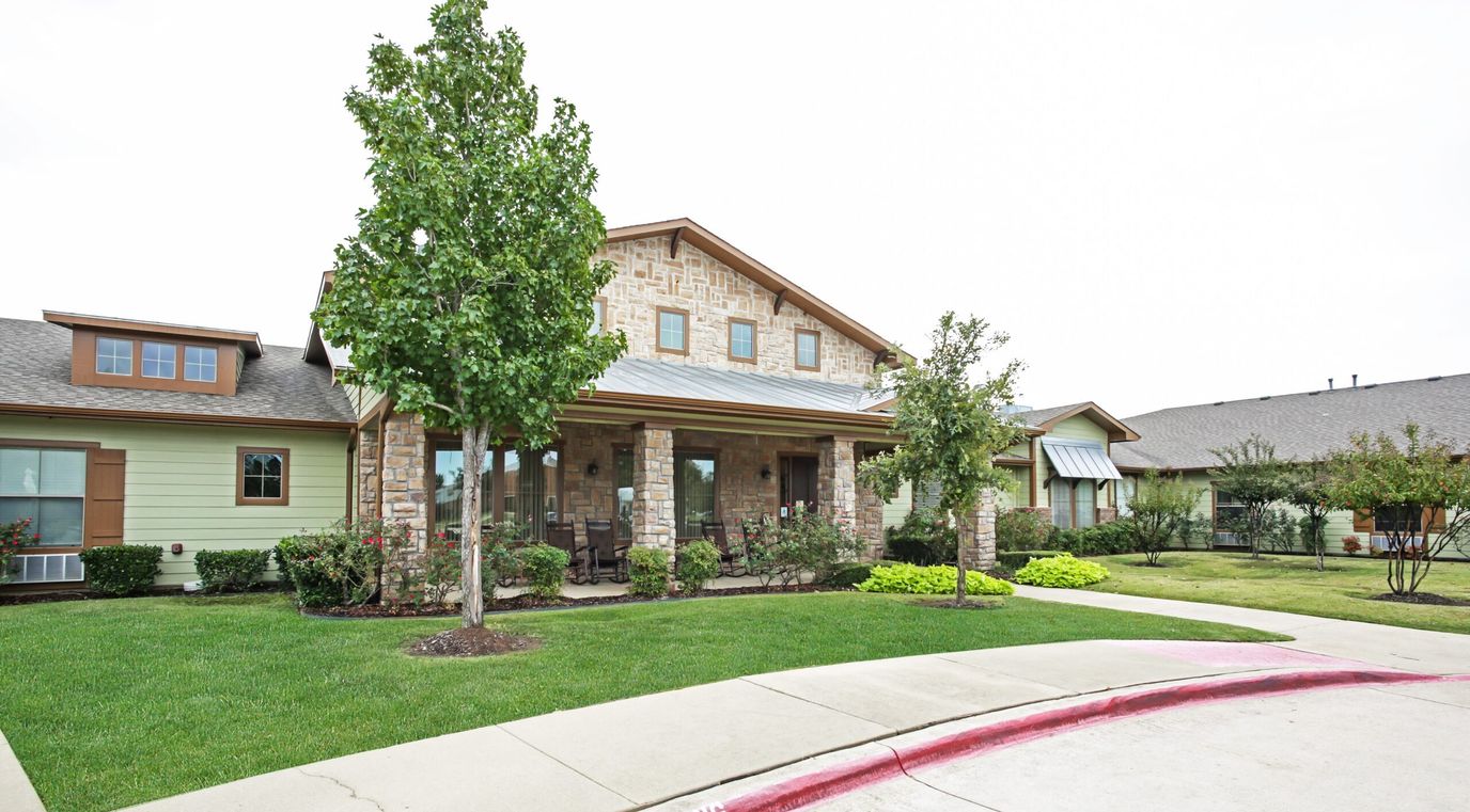 Exterior view of a senior living facility with landscaped garden