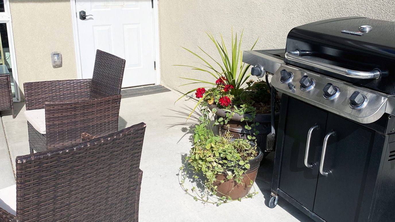 Outdoor grilling area with seating and plants