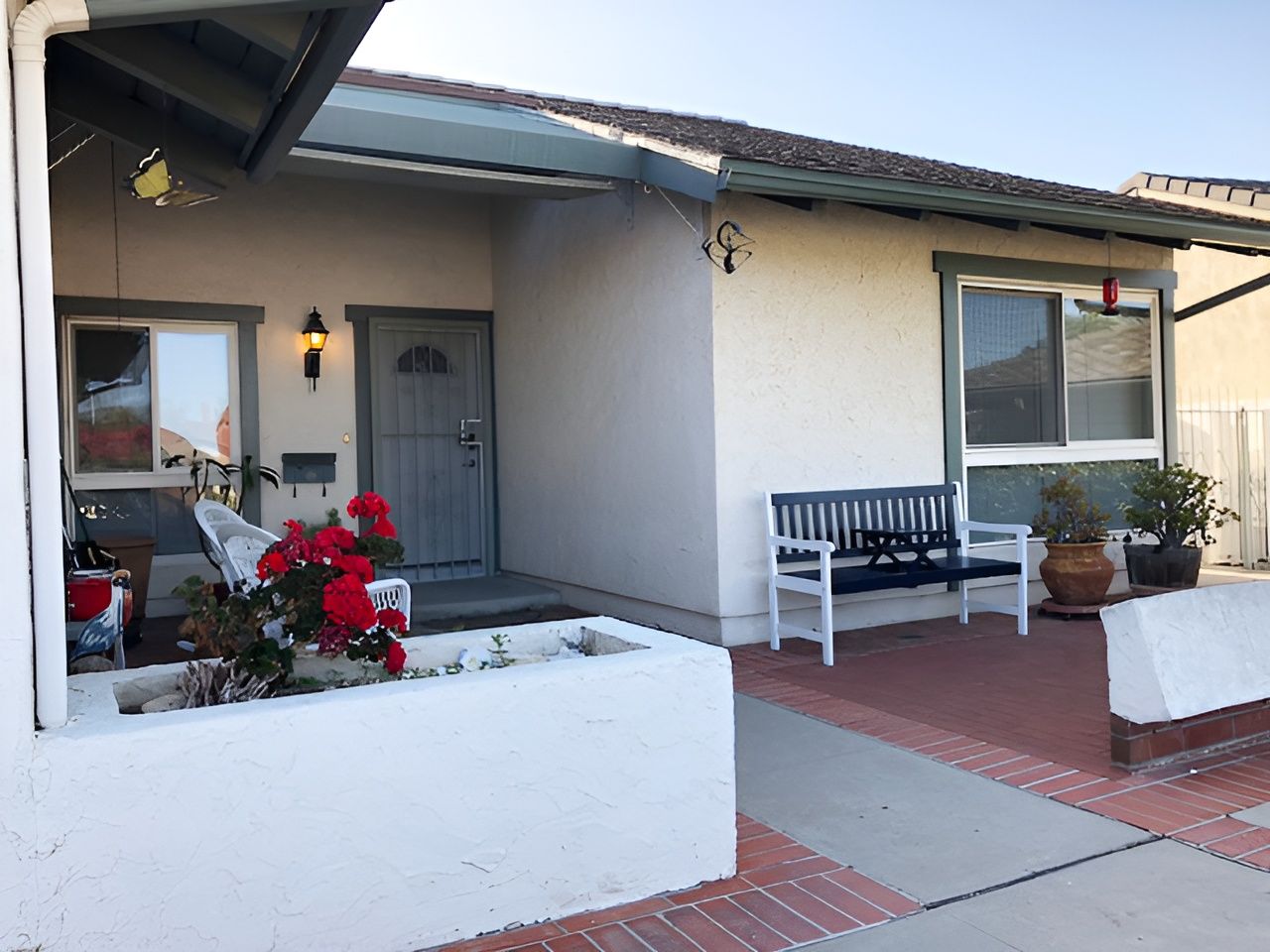 Welcoming exterior entrance with flowers and seating
