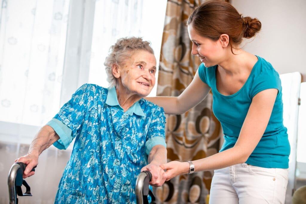 Senior woman with caregiver sharing a moment indoors.