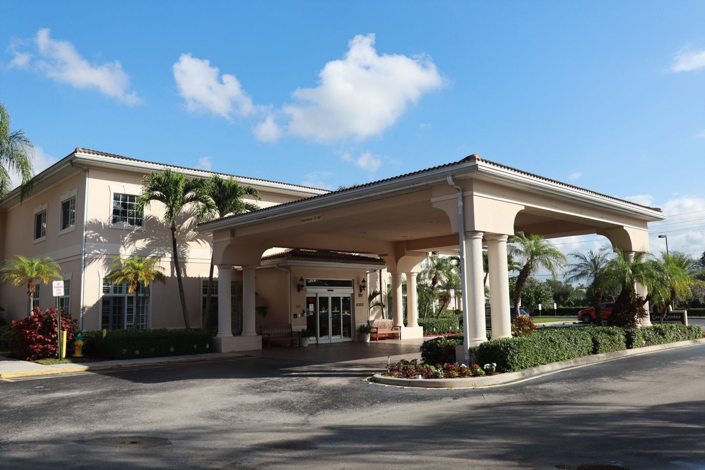 Exterior view of the facility entrance with palm trees