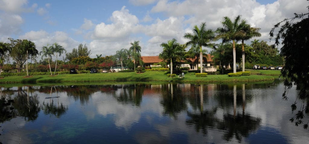 Outdoor view of Victoria Villa with palm trees and water reflection