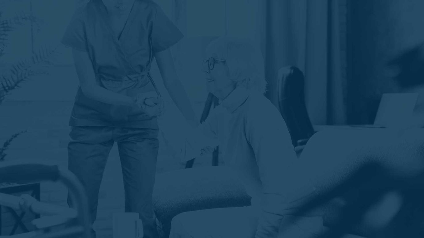 Caregiver assisting resident in a cozy living room