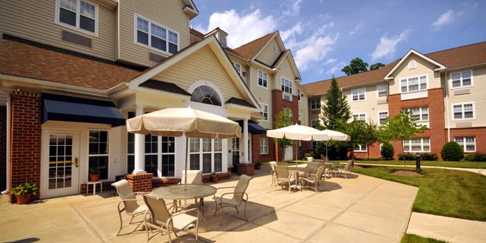 Exterior view of a senior living facility courtyard with seating
