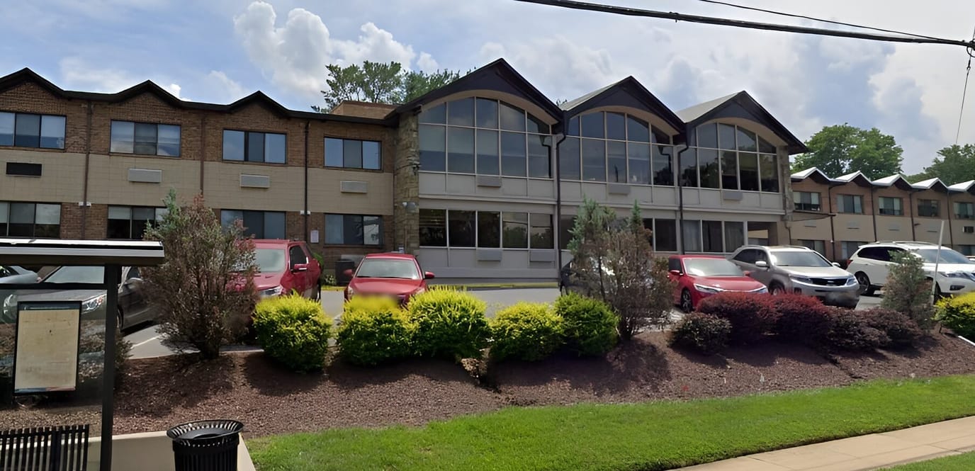 Exterior view of Montcare Bethesda with landscaping and vehicles