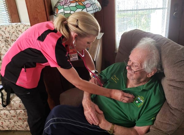 Nurse checking a resident's heartbeat in a cozy room