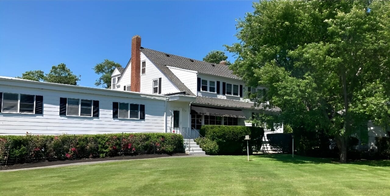 Exterior view of the facility with green lawn and trees