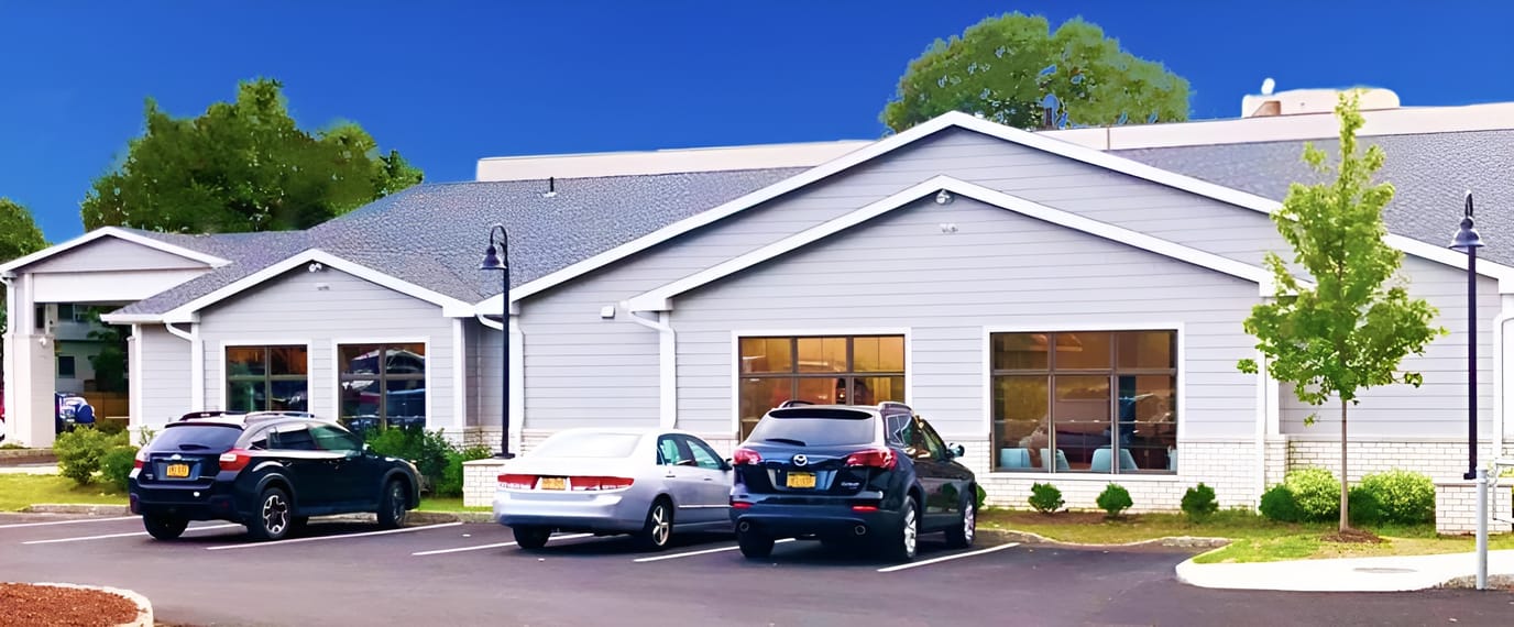 Exterior view of a nursing facility with vehicles parked