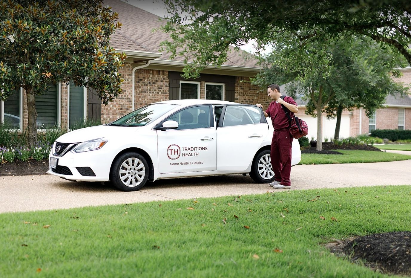Healthcare worker approaching a vehicle in a residential area