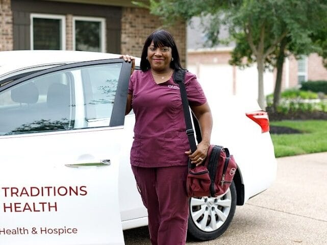 Staff member beside the Traditions Health vehicle.