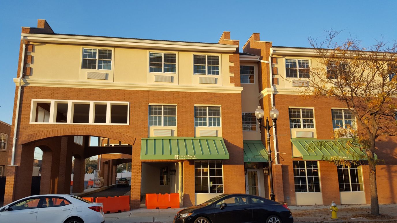 Exterior view of the Village Walk building with sunny backdrop