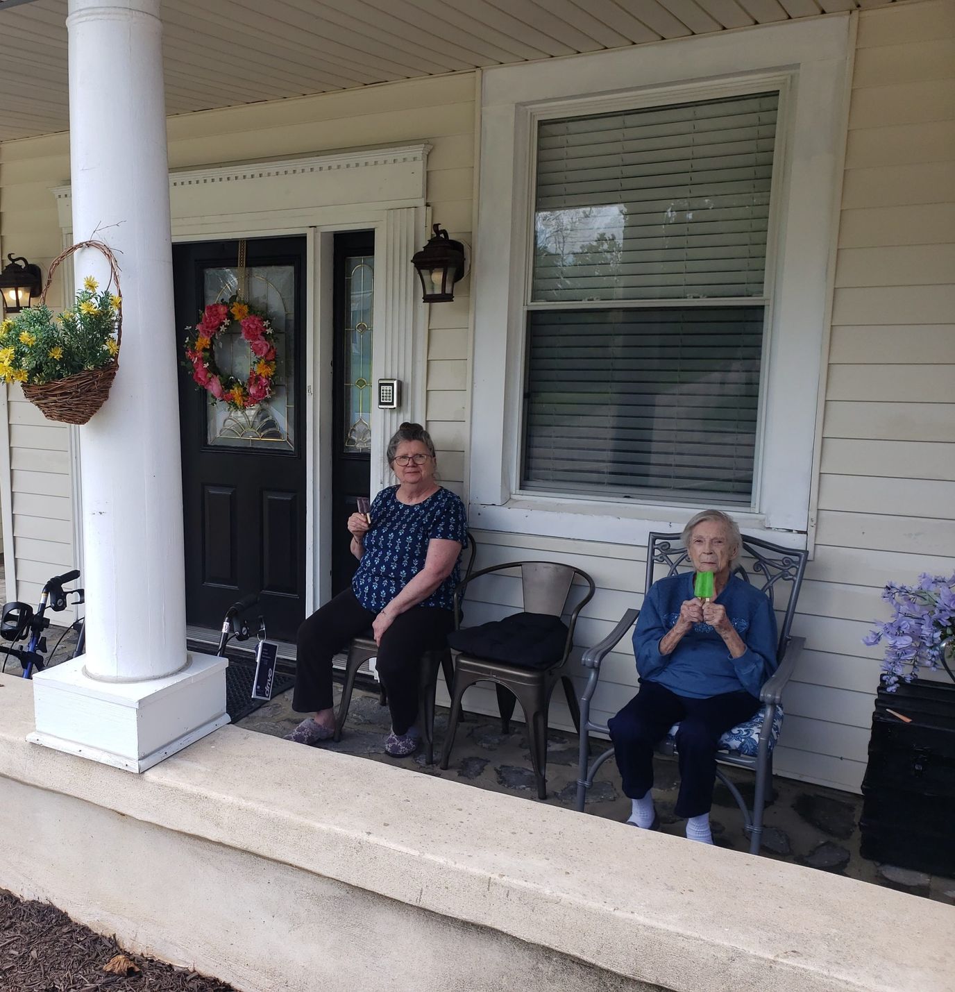Two residents enjoying time on the porch of the facility