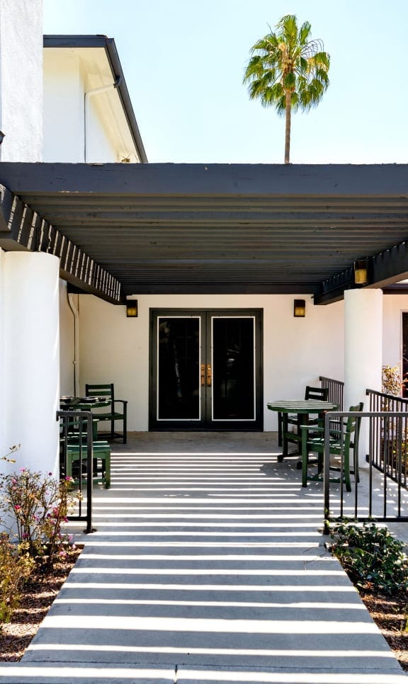 Entrance area with patio seating and palm tree