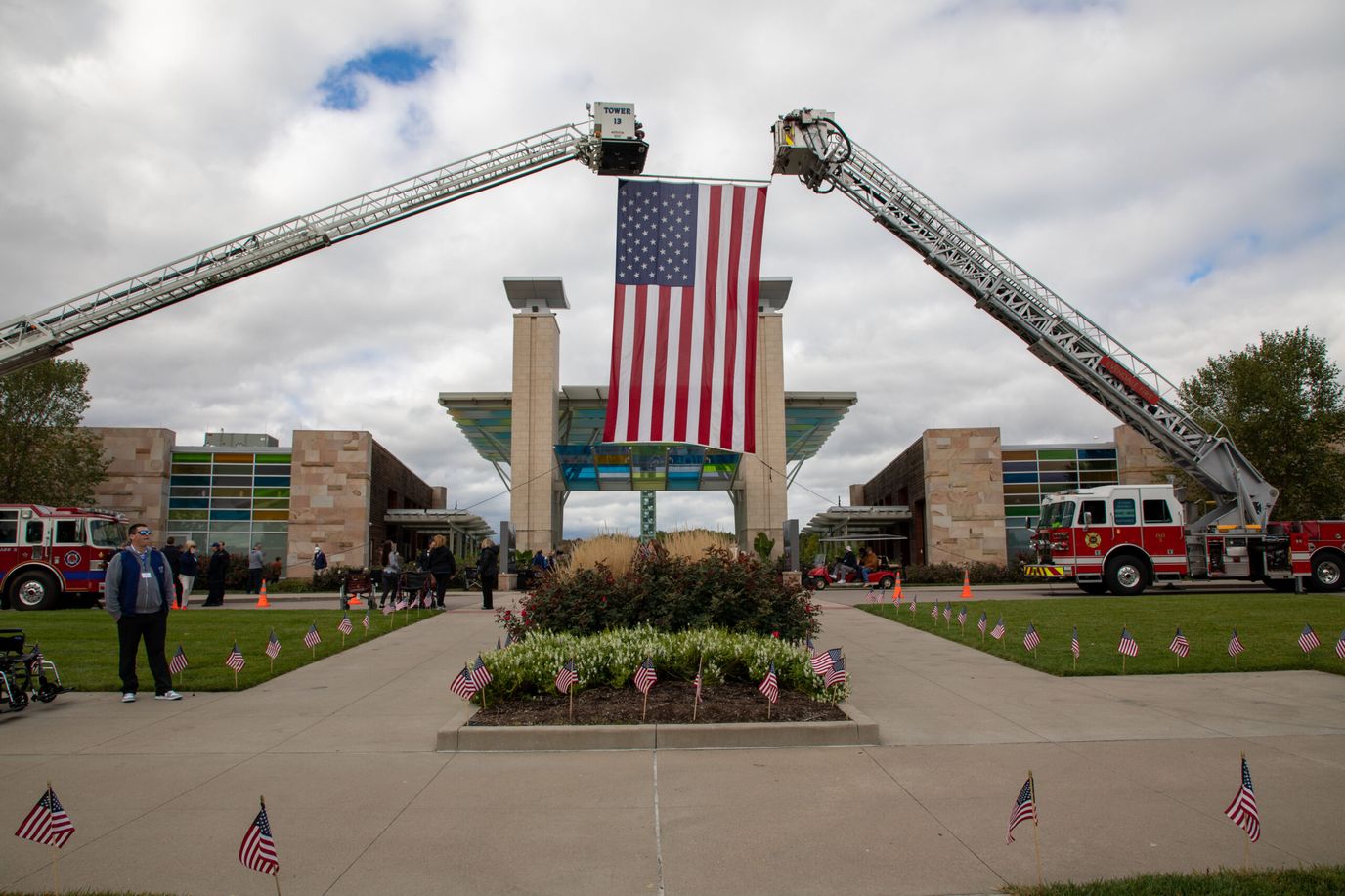 Entrance of the facility with a large American flag and fire trucks.
