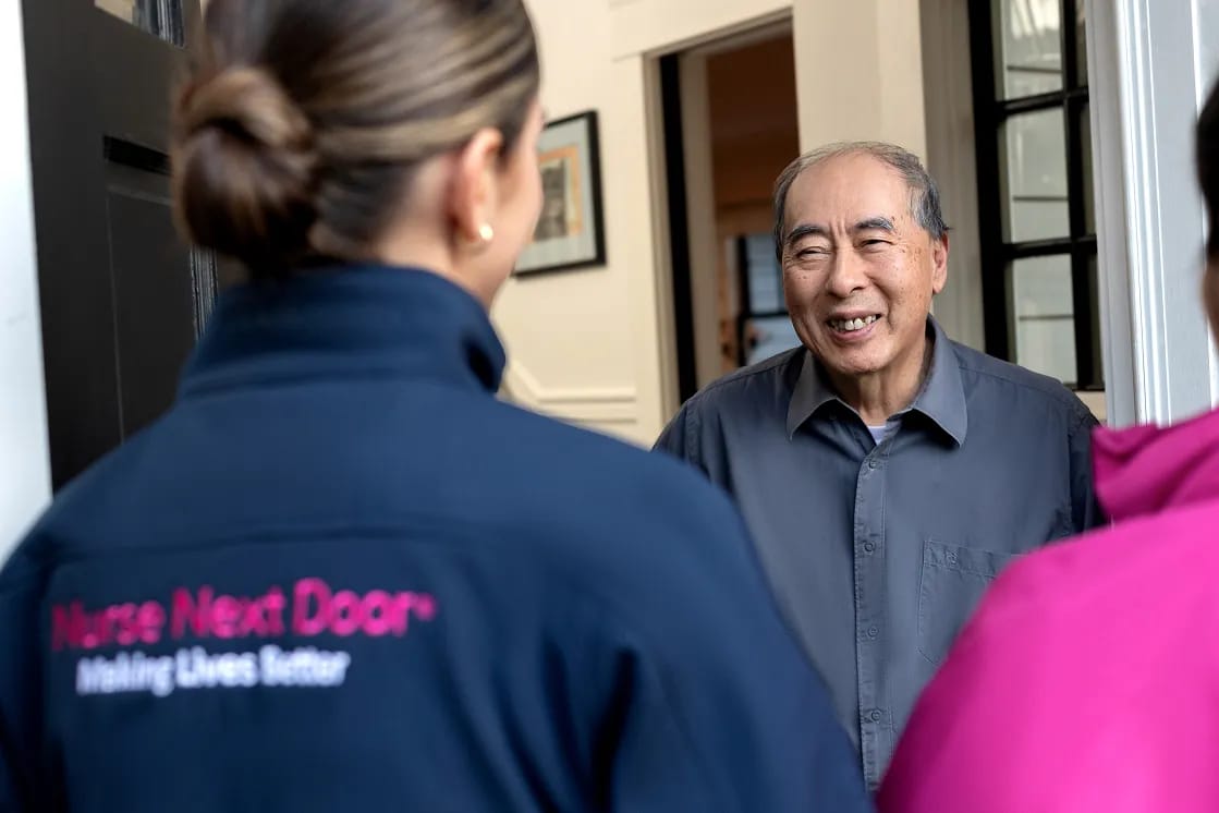 A staff member greeting a resident at the facility entrance